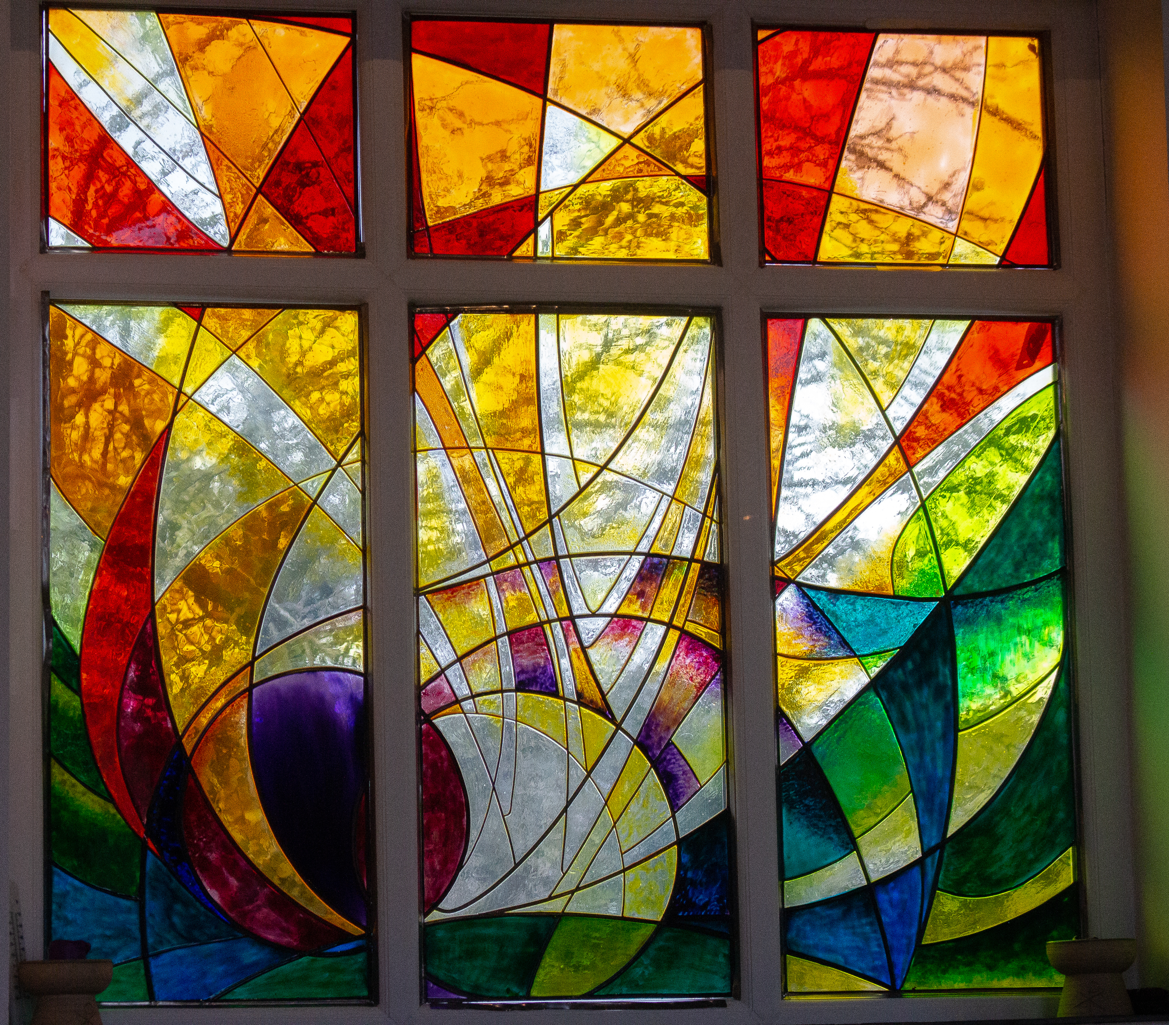 Modern stained glass window, reds, oranges and yellows. 